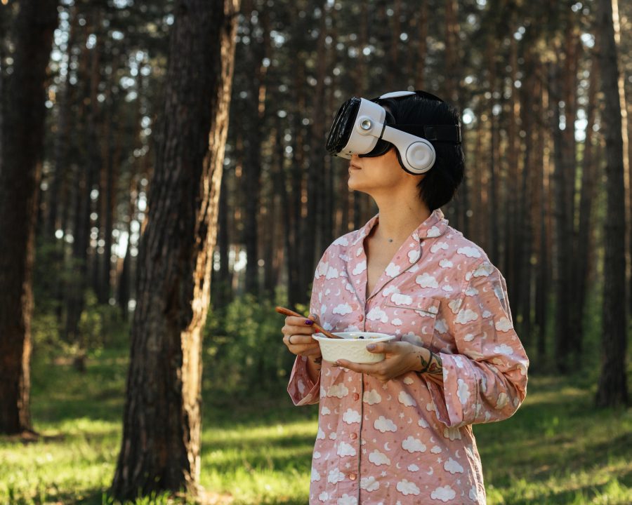 Utforma framtidens hållbara mobilitets- eller matsystem. Bild på kvinna med VR-mask i en skog. Hon håller i en skål med bär.