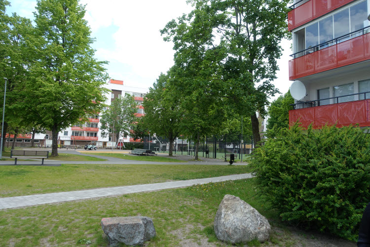 Minska byggnaders klimatpåverkan. Foto inifrån ett bostadsområde med många träd.